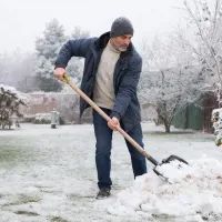 Мужчина чистит снег