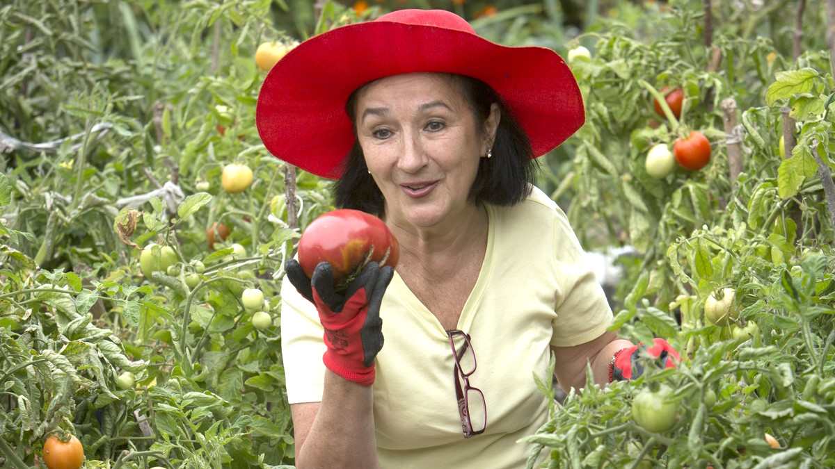 Женщина с большим помидором в руке